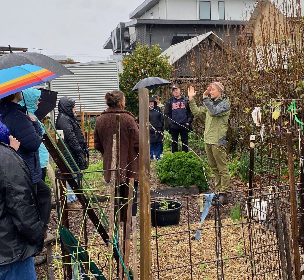 Permaculture expert Ben Shaw is holding arms in v shape showing the correct way to prune fruit trees